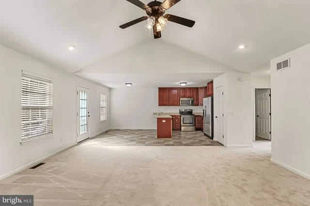 a view of a livingroom with a ceiling fan and window