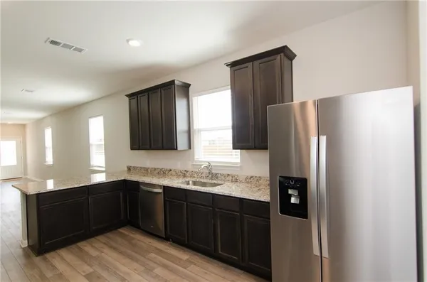 a kitchen with stainless steel appliances granite countertop refrigerator sink and cabinets