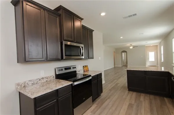 a kitchen with stainless steel appliances granite countertop a refrigerator and a sink