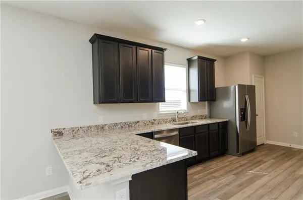 a view of kitchen with wooden floor and electronic appliances