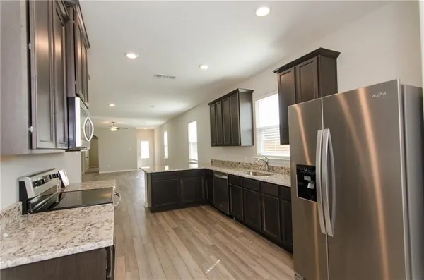 a kitchen with stainless steel appliances granite countertop a sink stove and refrigerator