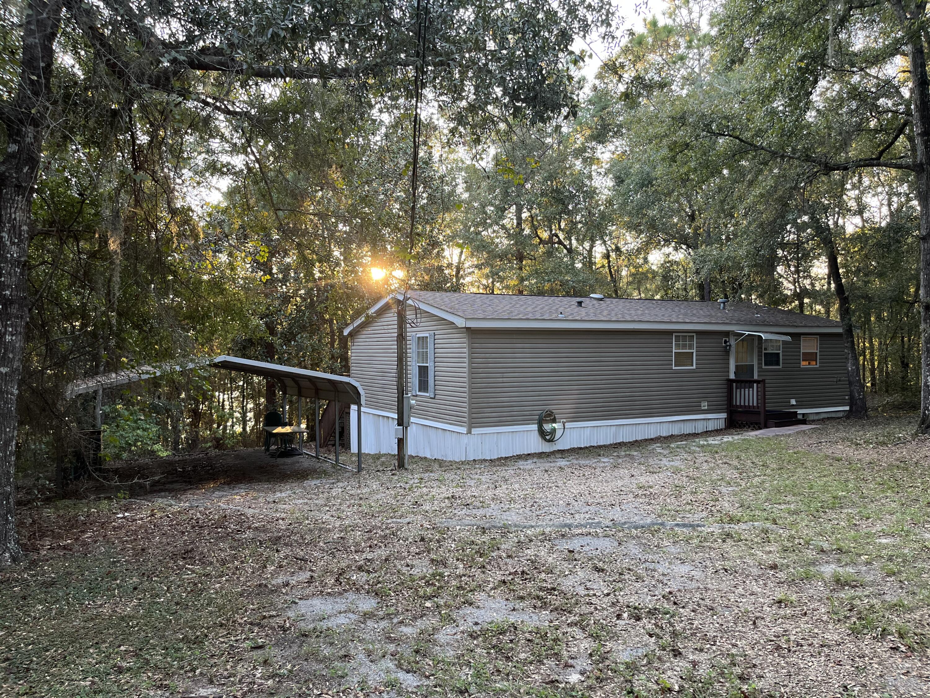 1104 Cat Island Road DeFuniak Springs, FL 32433 - Photo 4 of 28 a view of a house with a large tree and a car parked