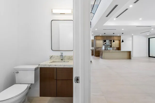 a bathroom with a granite countertop sink a toilet and a mirror