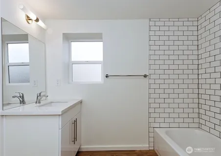 a bathroom with a sink a mirror and a bathtub