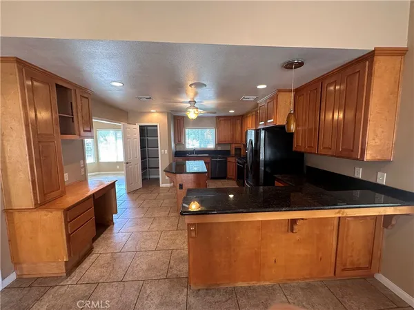 a kitchen with stainless steel appliances granite countertop a sink and a refrigerator