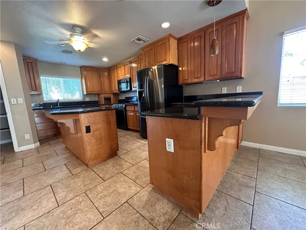 a kitchen with stainless steel appliances granite countertop a stove top oven a sink dishwasher and a refrigerator