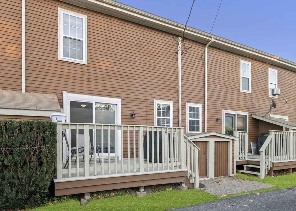 9 Sudbury Street, Unit 9 Maynard, MA 01754 - Photo 27 of 35 a view of a house with a small yard and wooden fence