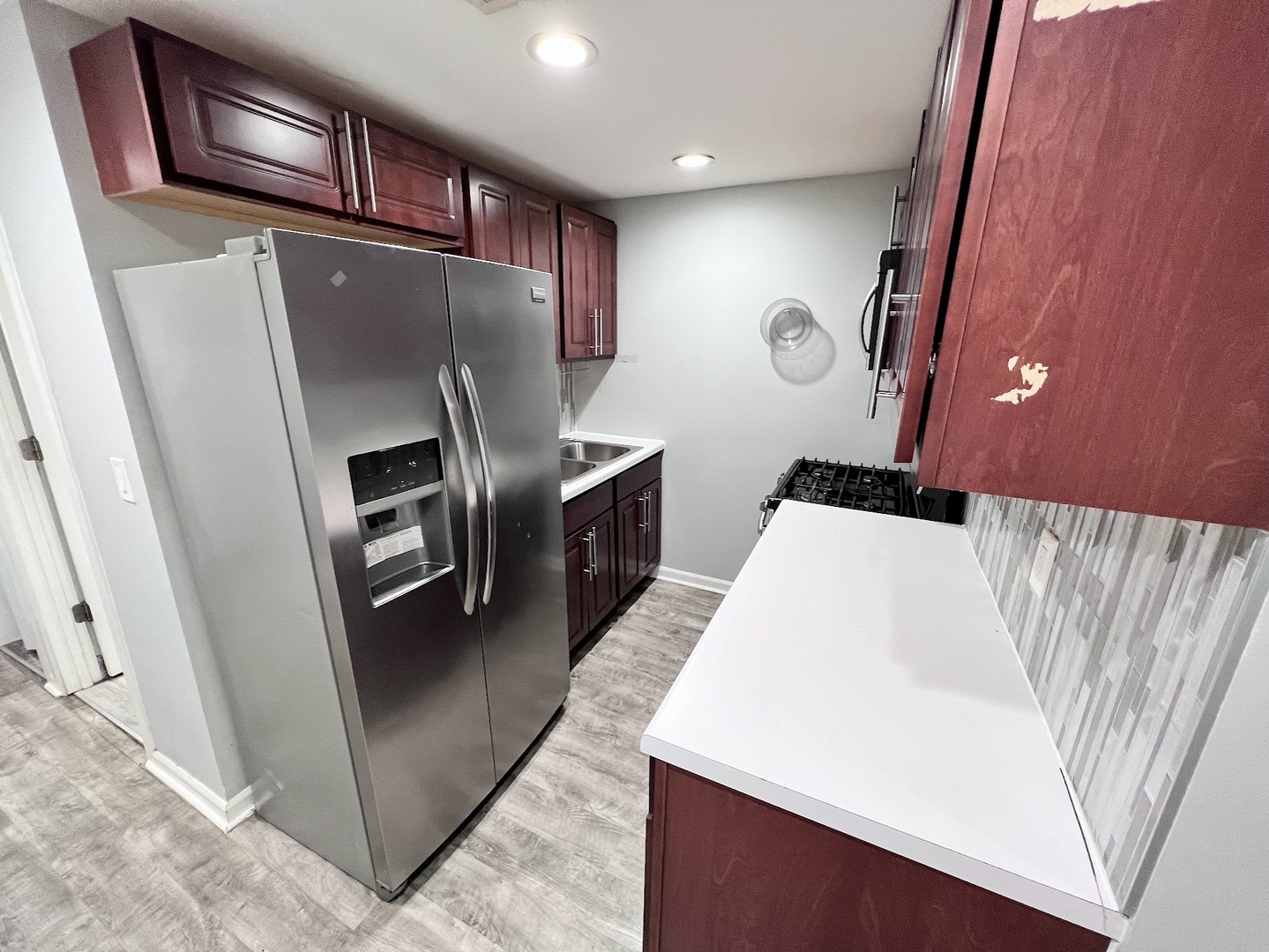 3335 North Kenneth Avenue, Unit G Chicago, IL 60641 - Photo 4 of 13 a kitchen with stainless steel appliances a refrigerator a sink a stove and island