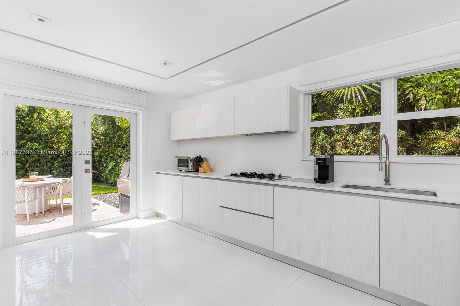 3020 Alton Road Miami Beach, FL 33140 - Photo 11 of 29 a kitchen with a sink and white cabinets