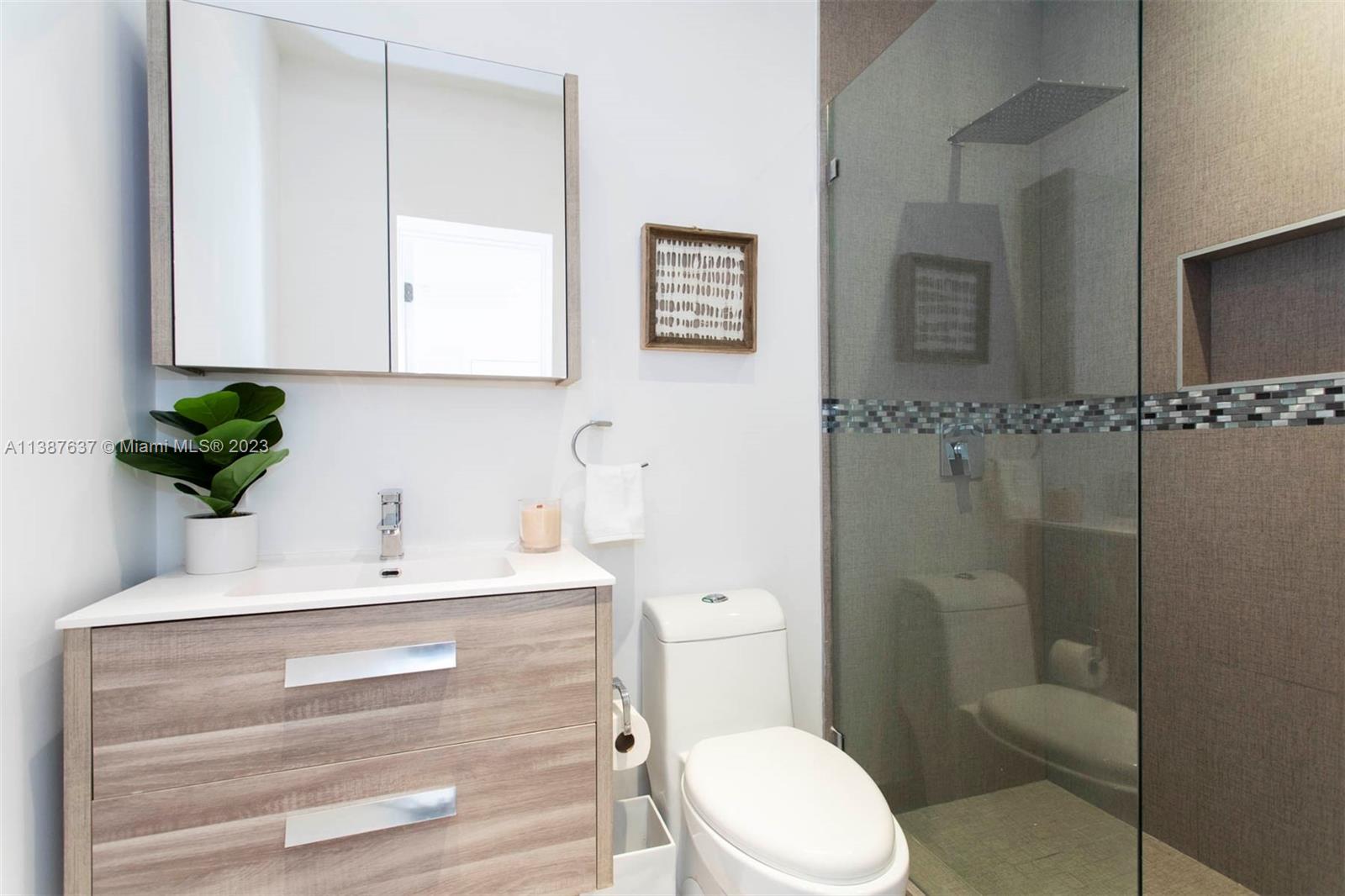 3020 Alton Road Miami Beach, FL 33140 - Photo 12 of 29 a bathroom with a sink a toilet and shower