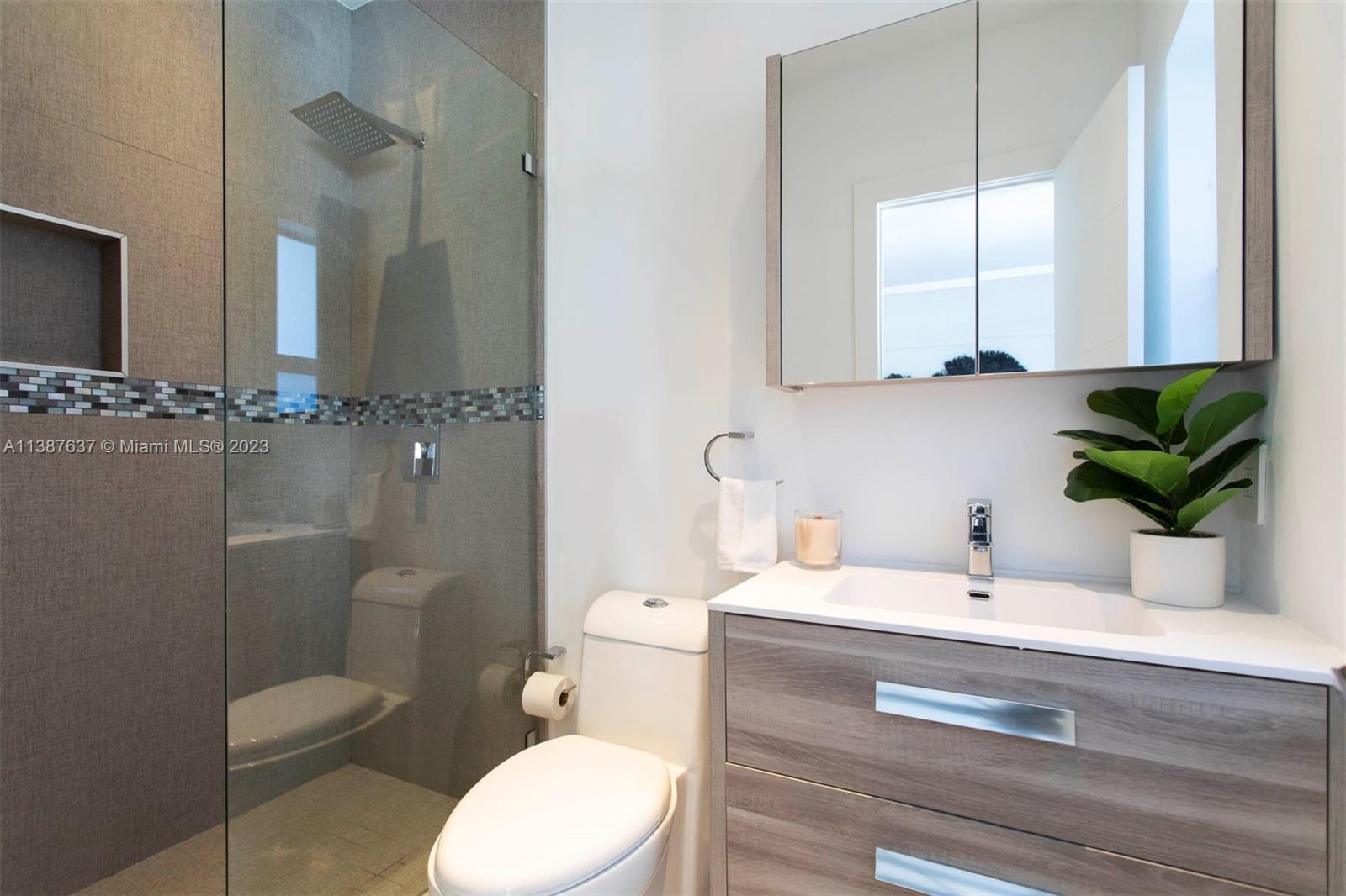 3020 Alton Road Miami Beach, FL 33140 - Photo 15 of 29 a bathroom with a sink a toilet and a mirror