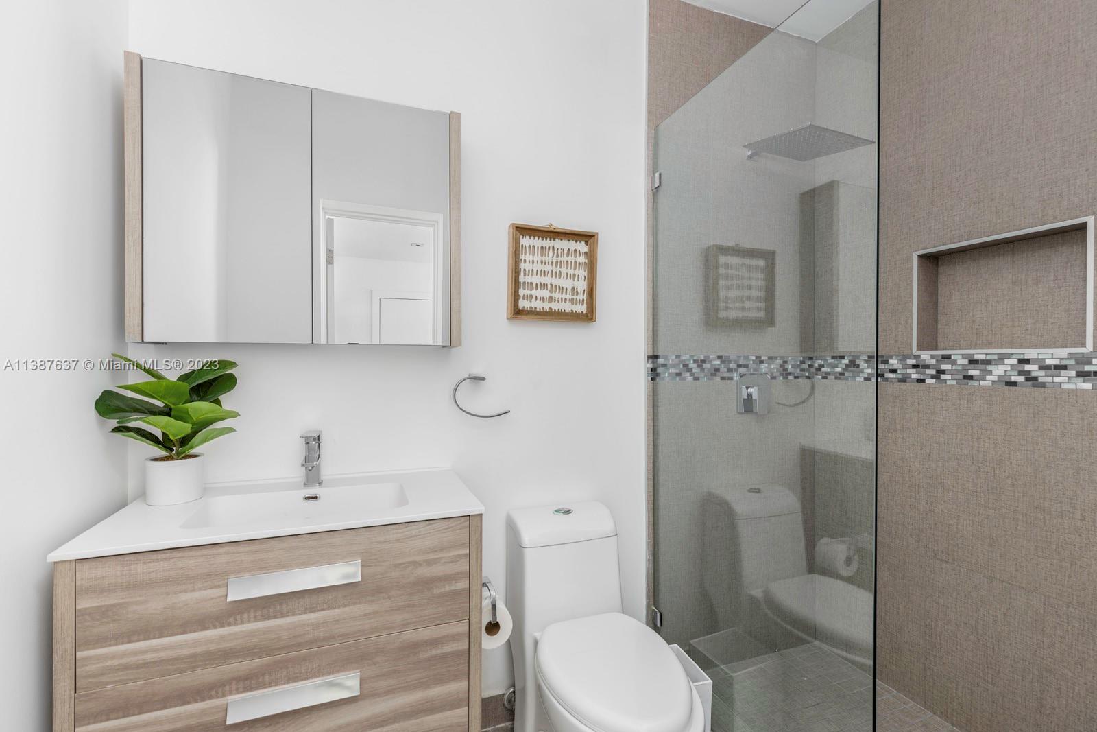 3020 Alton Road Miami Beach, FL 33140 - Photo 16 of 29 a bathroom with a sink a toilet and a mirror