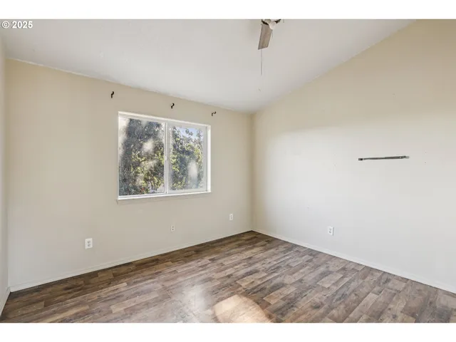 a view of an empty room with a window and closet