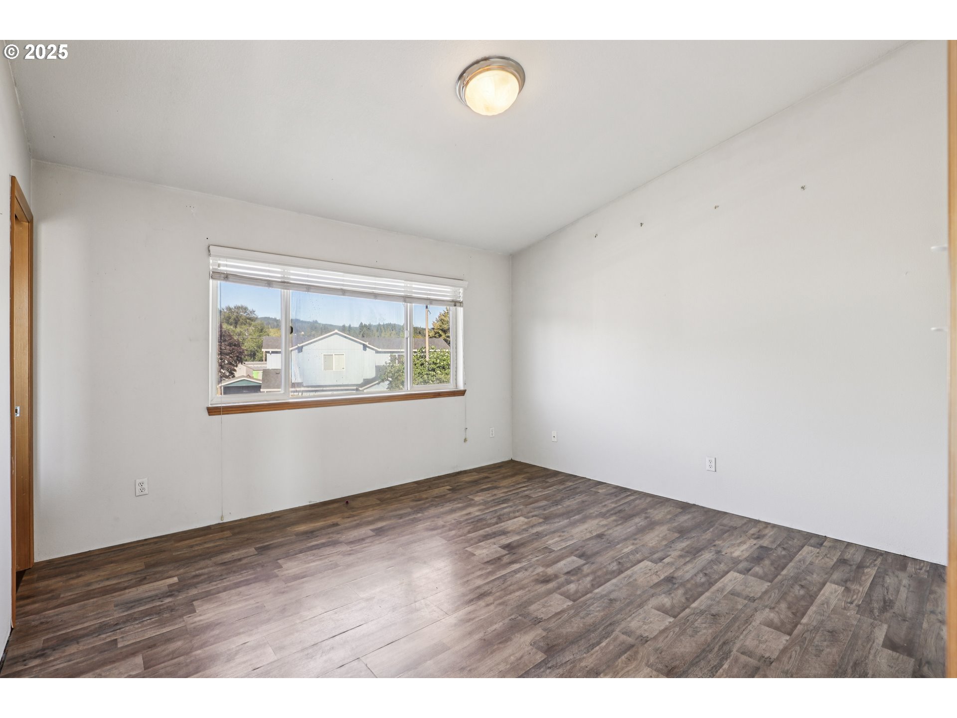 52866 Northeast 2nd Street Scappoose, OR 97056 - Photo 24 of 33 a view of an empty room with wooden floor and window