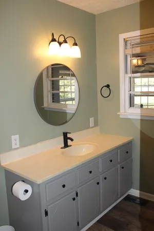 a bathroom with a sink a mirror and a window