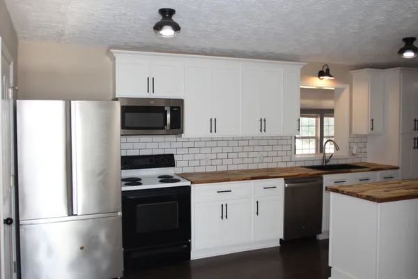 a kitchen with a sink stove and microwave