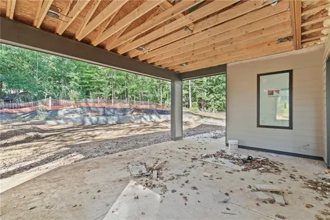 a view of a room with a large window and wooden roof
