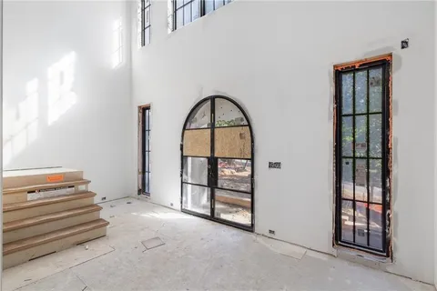 a view of a bedroom with furniture and window