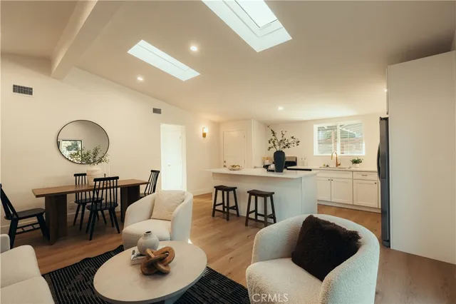 a living room with furniture kitchen view and a dining table