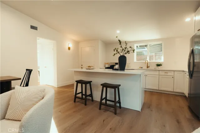 a kitchen with a sink cabinets and wooden floor