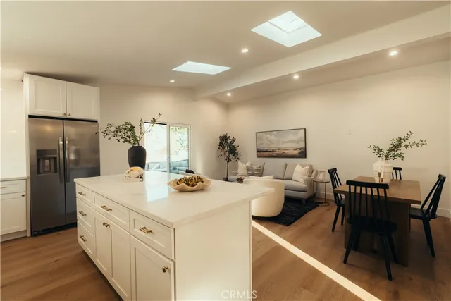 a view of a dining table chairs and refrigerator