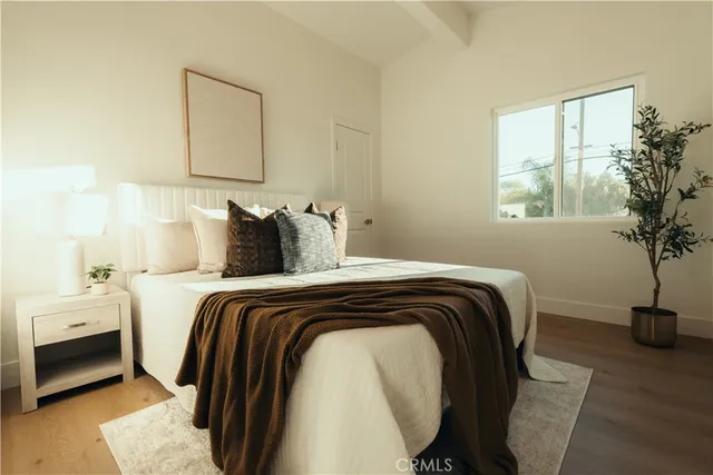 a bedroom with a bed and a potted plant