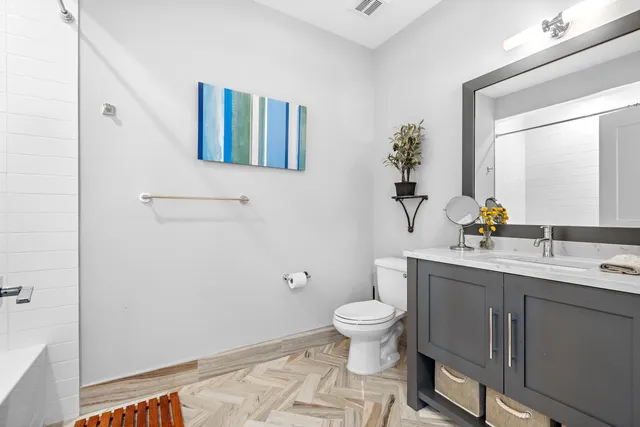 a bathroom with a sink a toilet and mirror