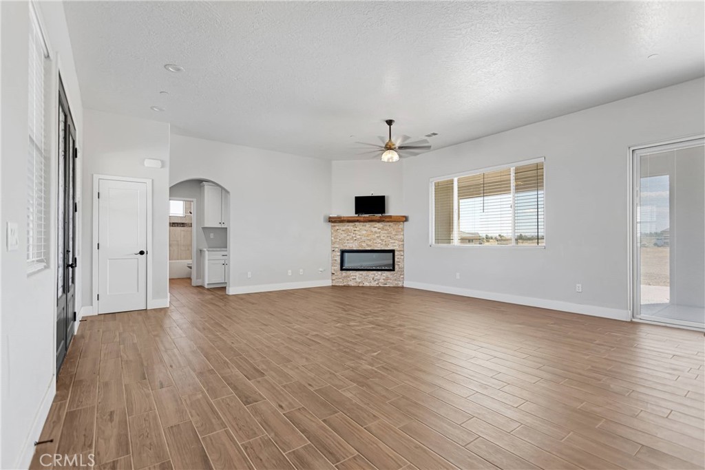 10055 Eaby Road Phelan, CA 92371 - Photo 5 of 19 an empty room with wooden floor chandelier and windows