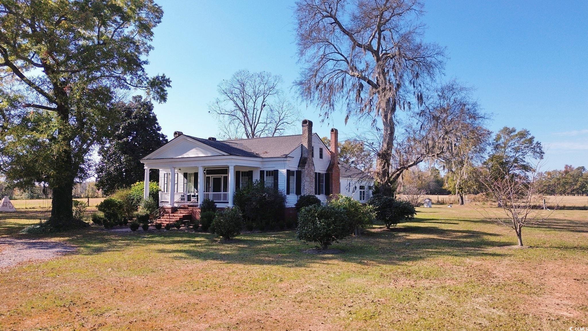 10463 County Line Road Hemingway, SC 29554 - Photo 31 of 40 View of front of home featuring covered porch, a front lawn, and a chimney