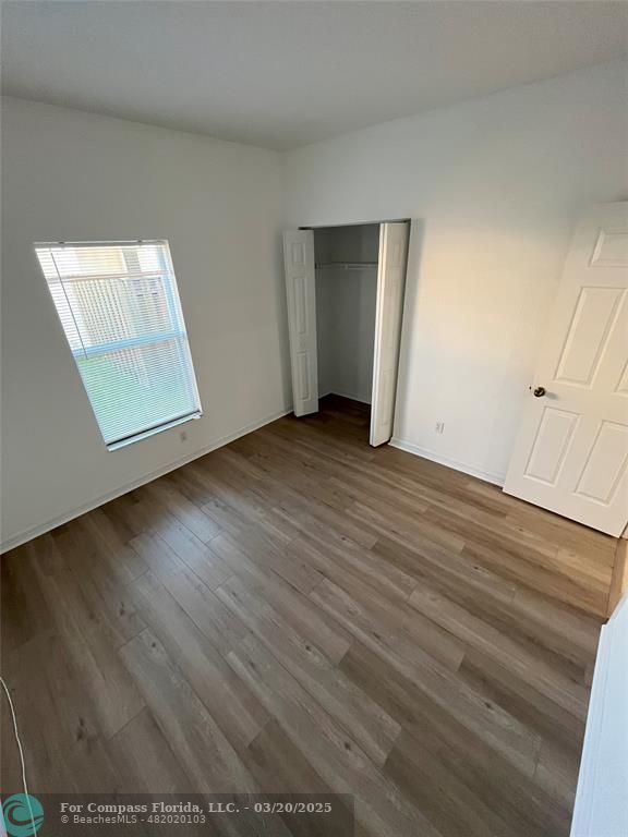 9704 Windrift Circle Fort Pierce, FL 34945 - Photo 13 of 21 an empty room with wooden floor and mirror