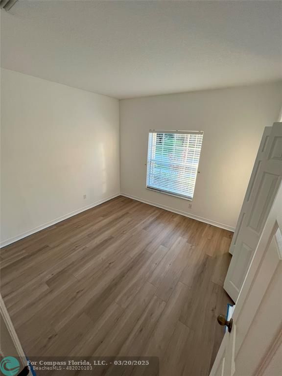 9704 Windrift Circle Fort Pierce, FL 34945 - Photo 14 of 21 a view of an empty room with wooden floor and a window