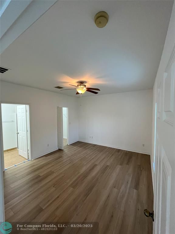 9704 Windrift Circle Fort Pierce, FL 34945 - Photo 8 of 21 an empty room with wooden floor and windows