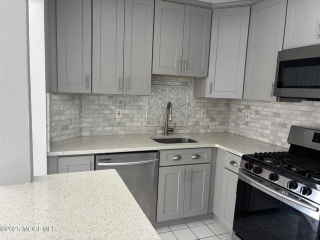 a kitchen with stainless steel appliances granite countertop a stove and a sink