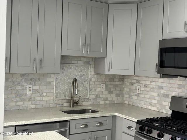 a kitchen with stainless steel appliances granite countertop white cabinets and a stove