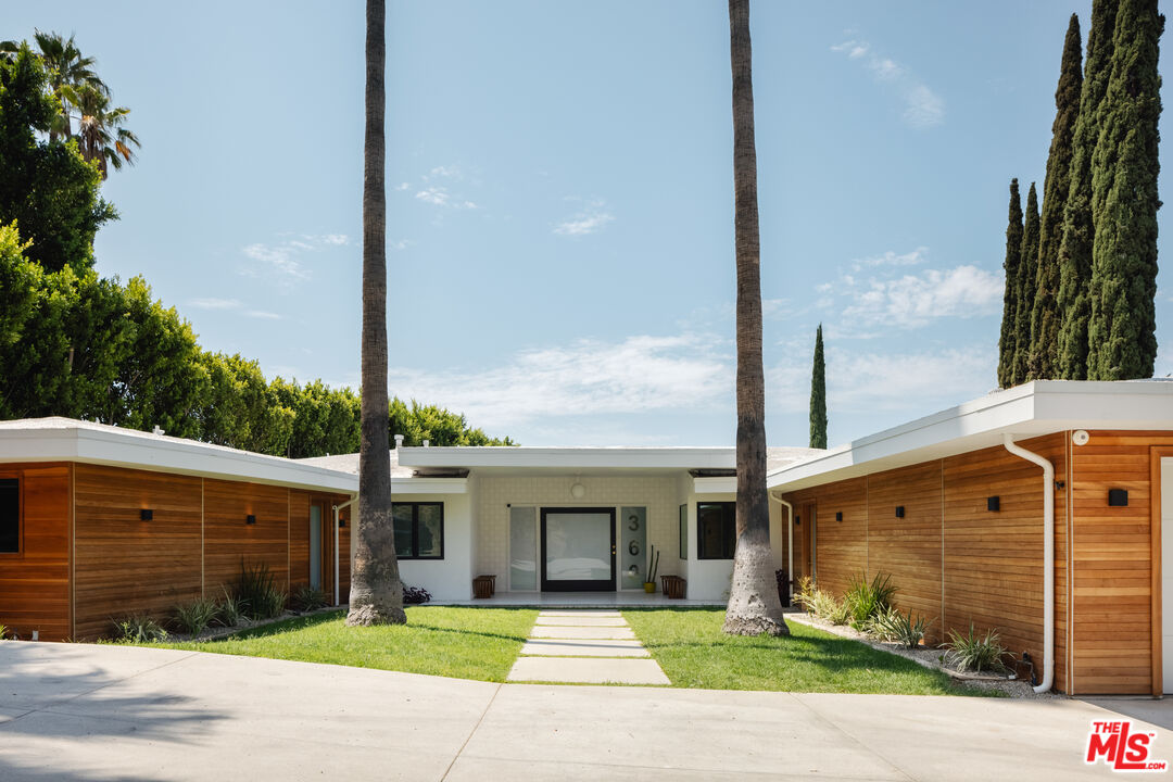 a front view of a house with a garden and plants
