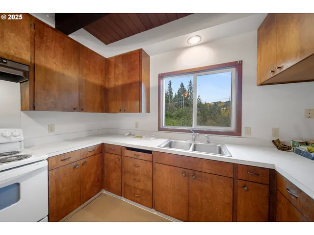 a kitchen with kitchen island a counter top space a sink stainless steel appliances and cabinets