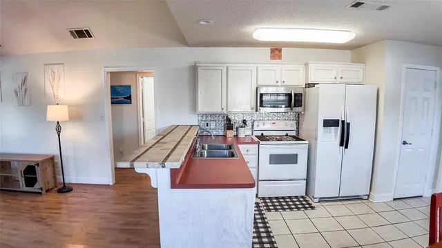 a kitchen with stainless steel appliances a stove a sink and a refrigerator