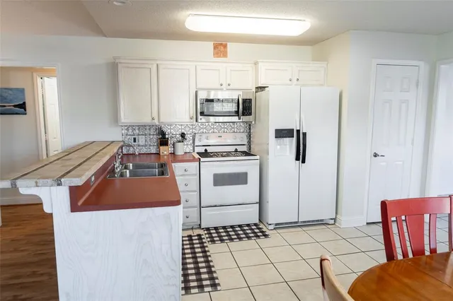 a kitchen with stainless steel appliances a stove a sink and a refrigerator