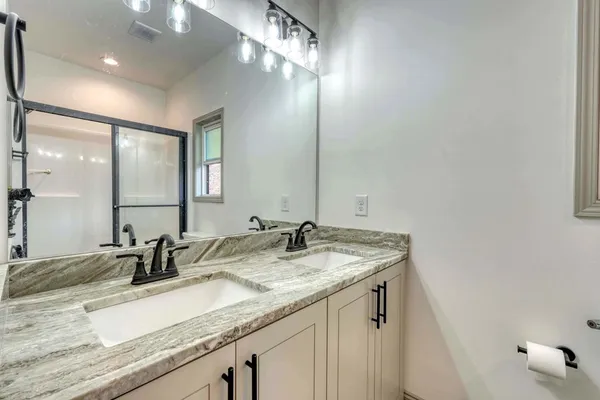a bathroom with a granite countertop sink and a mirror