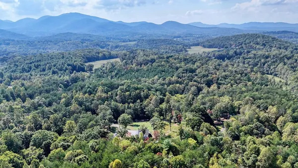 a view of a mountain range with lush green forest