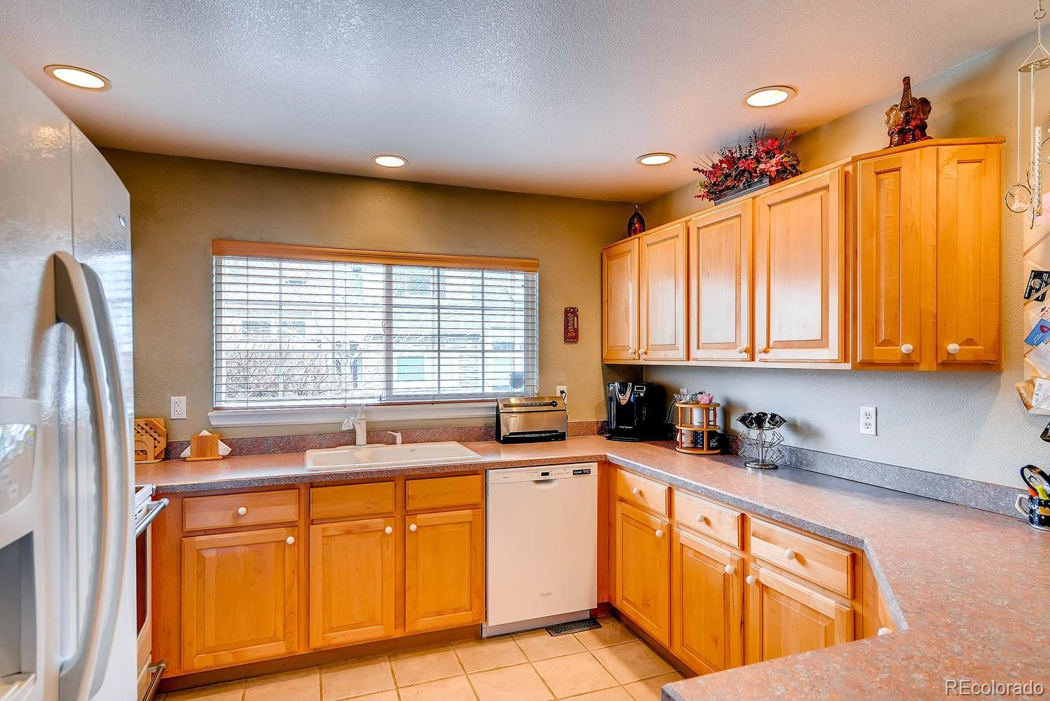 6207 Trailhead Road Highlands Ranch, CO 80130 - Photo 12 of 28 a kitchen with stainless steel appliances sink cabinets and window