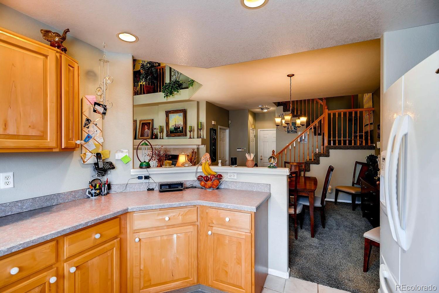 6207 Trailhead Road Highlands Ranch, CO 80130 - Photo 13 of 28 a kitchen with stainless steel appliances kitchen island granite countertop a stove and cabinets