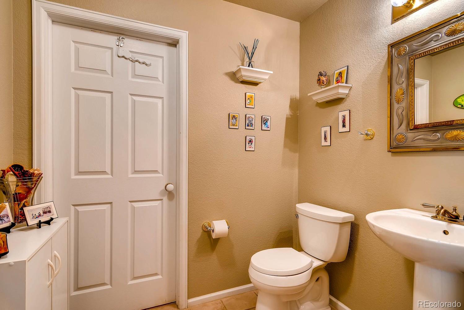 6207 Trailhead Road Highlands Ranch, CO 80130 - Photo 14 of 28 a white toilet sitting next to a bathroom sink