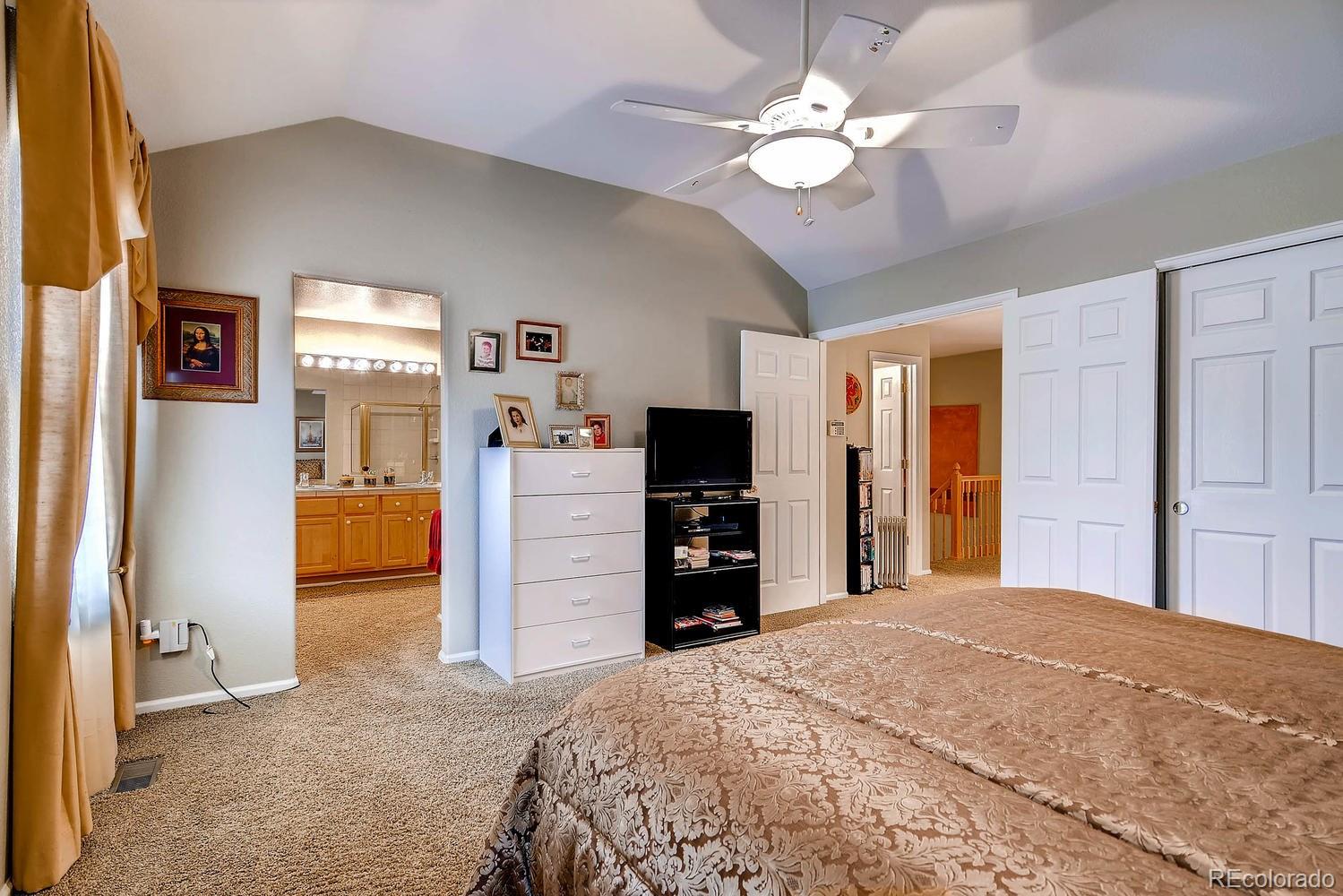 6207 Trailhead Road Highlands Ranch, CO 80130 - Photo 16 of 28 a bedroom with a bed and a flat tv screen