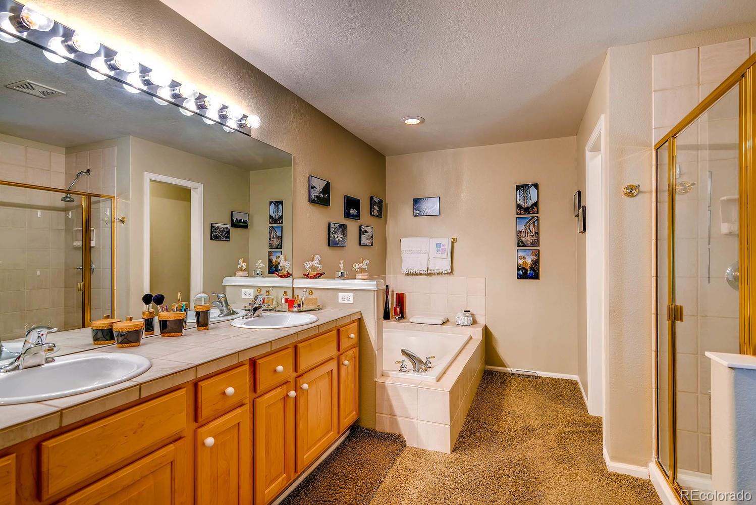 6207 Trailhead Road Highlands Ranch, CO 80130 - Photo 17 of 28 a spacious bathroom with a double vanity sink a mirror and a bathtub