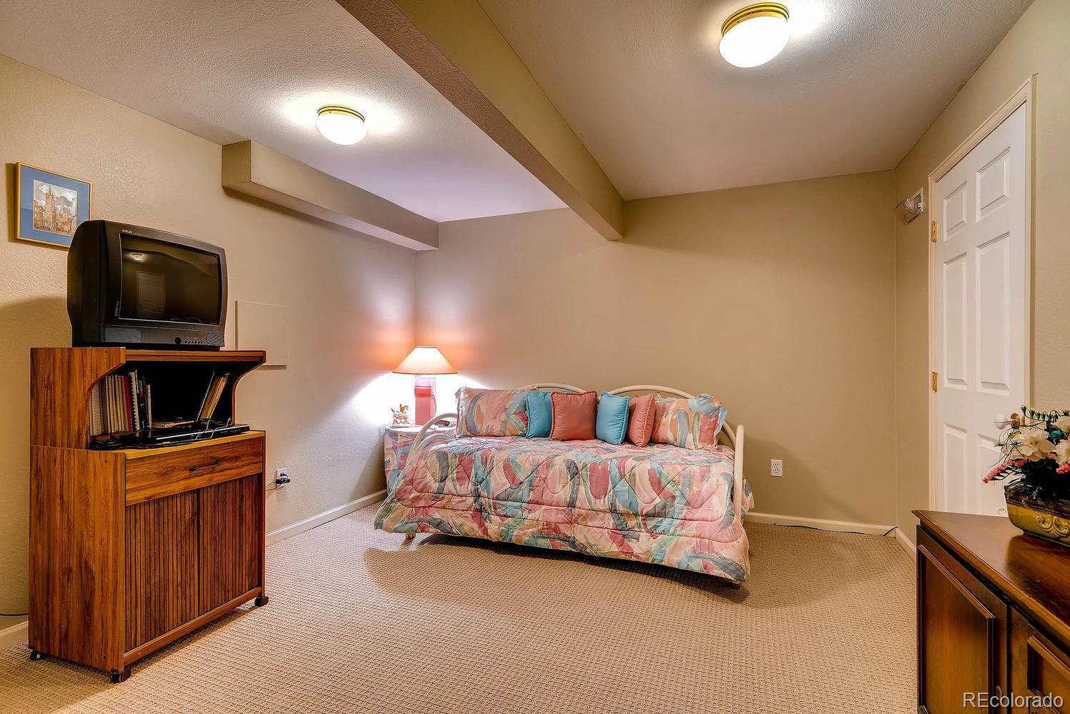 6207 Trailhead Road Highlands Ranch, CO 80130 - Photo 22 of 28 a bed room with a bed and a television