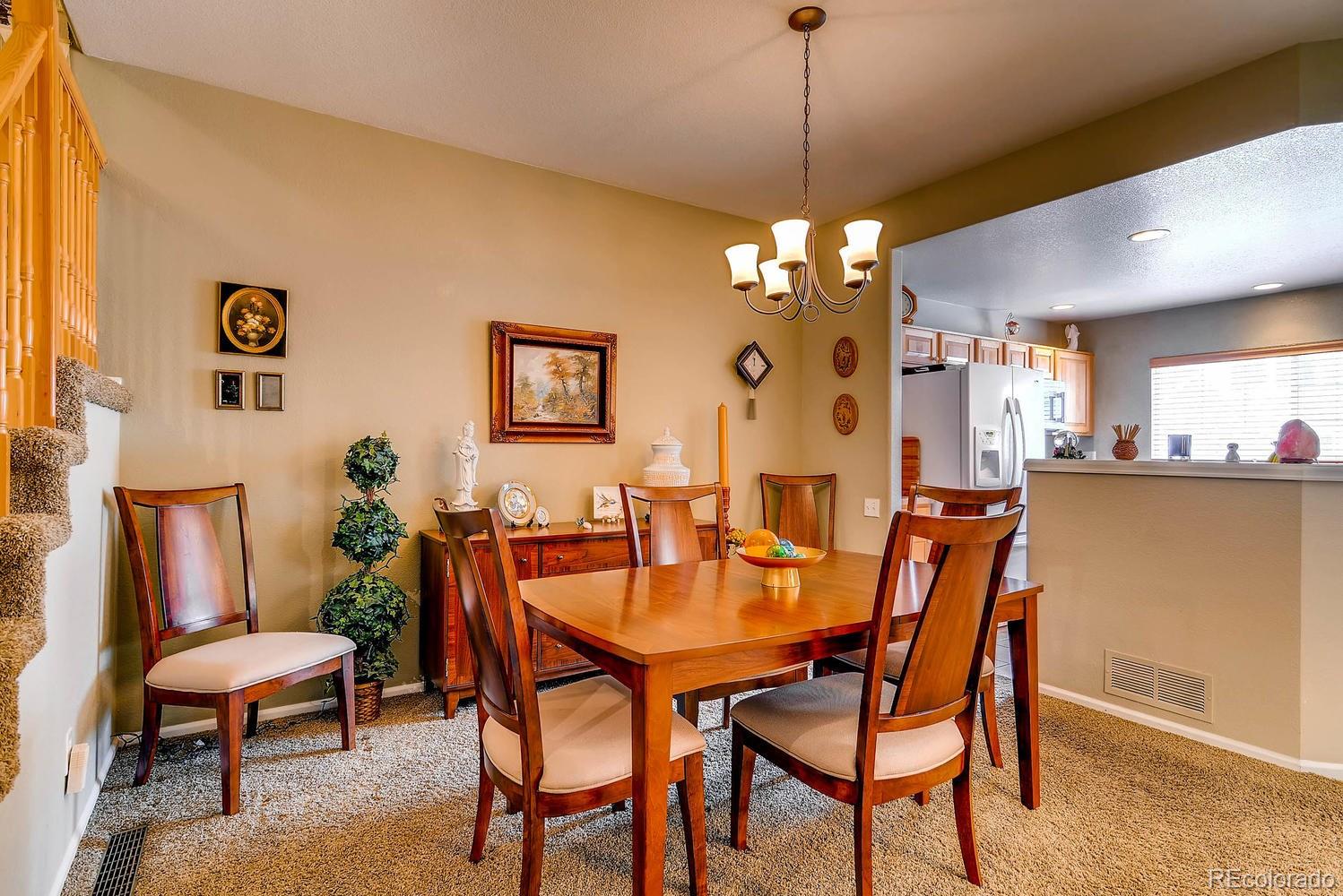 6207 Trailhead Road Highlands Ranch, CO 80130 - Photo 9 of 28 a view of a dining room with furniture and chandelier