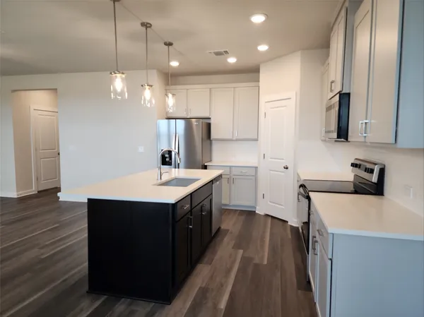 a kitchen with a sink stainless steel appliances a counter space and cabinets