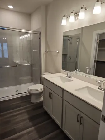 a bathroom with a double vanity sink toilet and shower