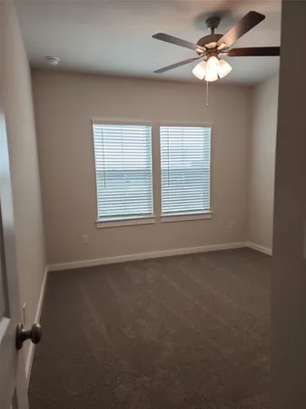 en empty room with windows and fan